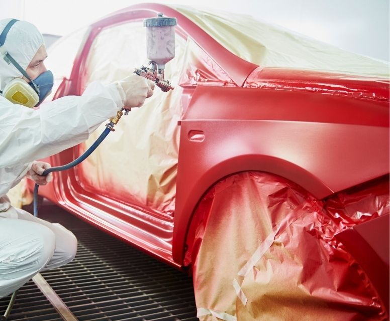 Técnico pintando coche en cabina con pintura profesional en taller de chapa y pintura en Pedralba Técnico pintando coche en cabina con pintura profesional en taller de chapa y pintura en Pedralba